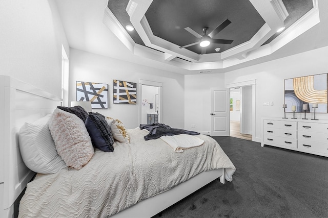 carpeted bedroom featuring ceiling fan, a tray ceiling, and crown molding