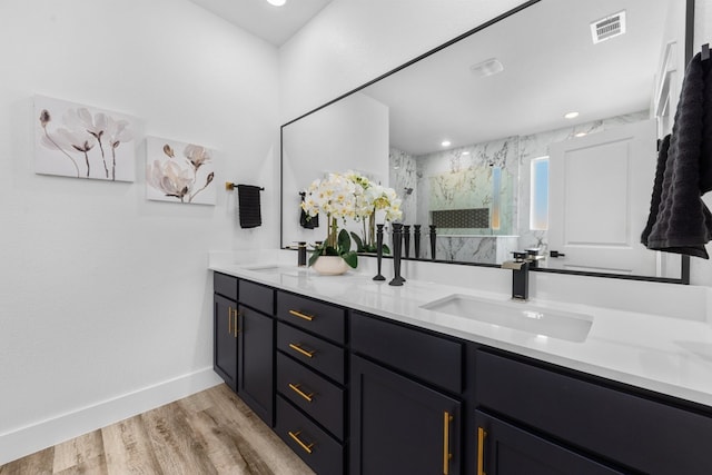 bathroom with wood-type flooring, vanity, and a shower with door