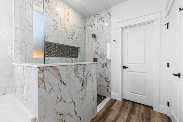 bathroom with hardwood / wood-style flooring and tiled shower