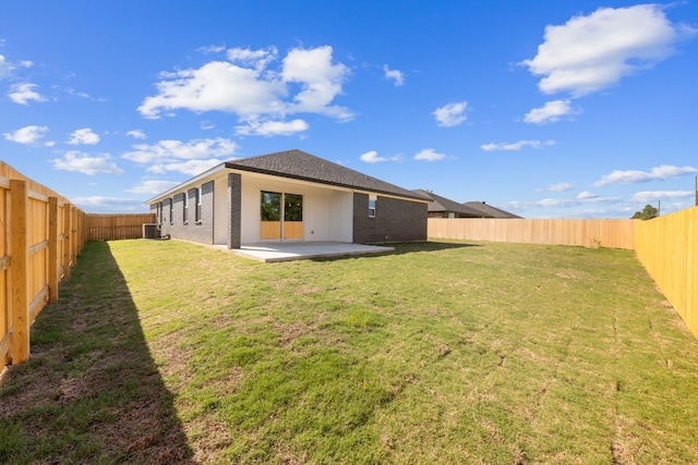 rear view of house with a patio, a yard, and cooling unit