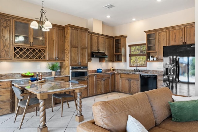 1120 Canyon View Rd, Dripping Springs, TX 78620 - kitchen featuring black appliances, under cabinet range hood, light stone countertops, decorative light fixtures, and glass insert cabinets