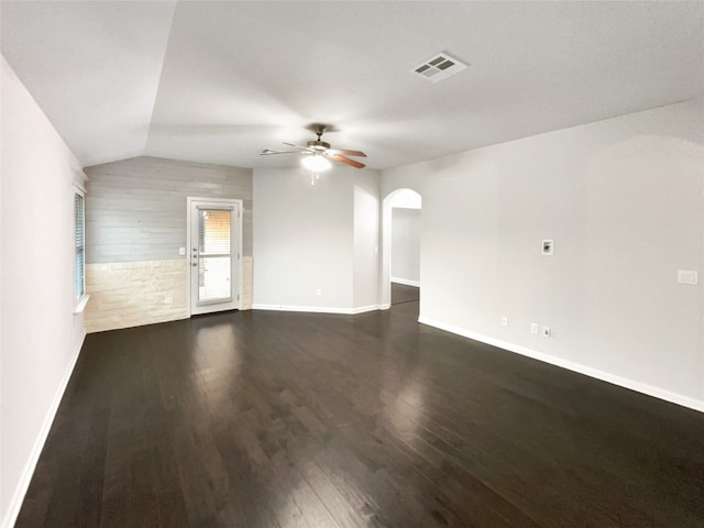 empty room with ceiling fan, dark hardwood / wood-style floors, and vaulted ceiling