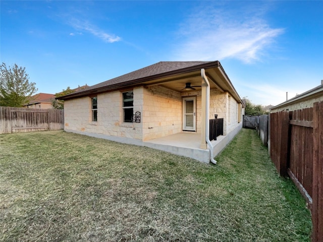 back of house with ceiling fan, a lawn, and a patio area