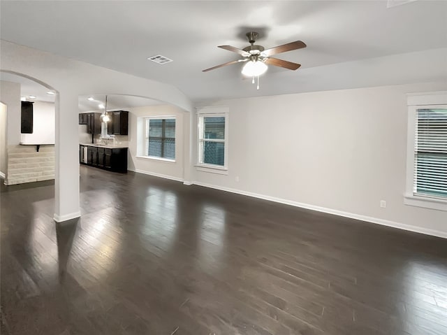 unfurnished living room with ceiling fan and dark hardwood / wood-style flooring