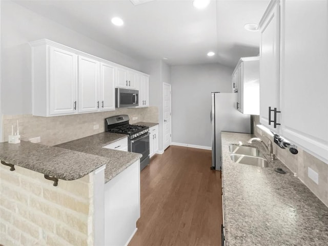 305 Rock Mill Loop, Georgetown, TX 78626 - kitchen featuring stainless steel appliances, a sink, white cabinetry, decorative backsplash, and a peninsula