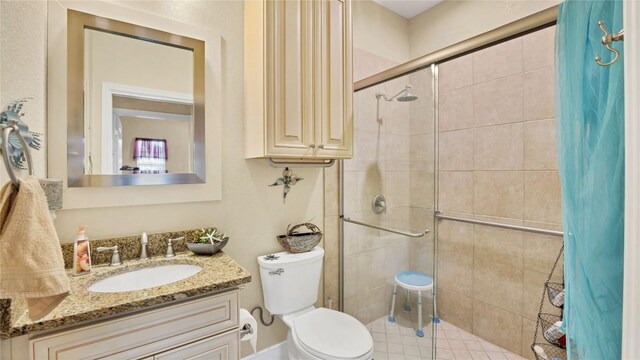 full bath with vanity, a shower stall, and toilet