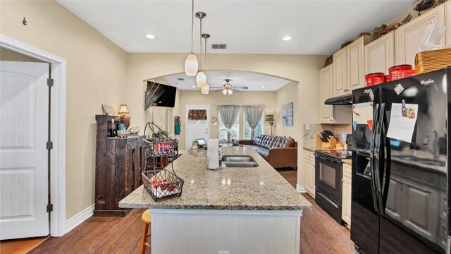 kitchen featuring visible vents, under cabinet range hood, arched walkways, black appliances, and a sink