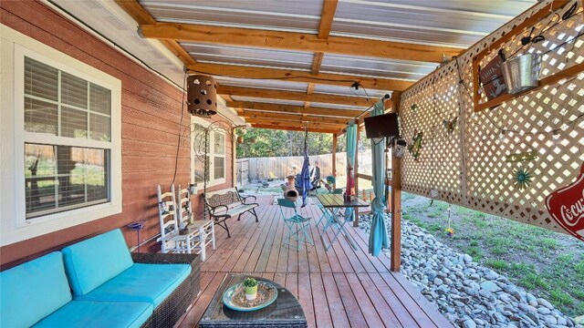 wooden terrace featuring an outdoor living space and fence