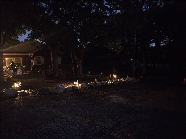 yard at twilight featuring an outdoor fire pit