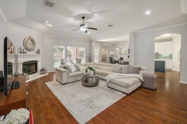 living room featuring ceiling fan, dark hardwood / wood-style floors, and ornamental molding