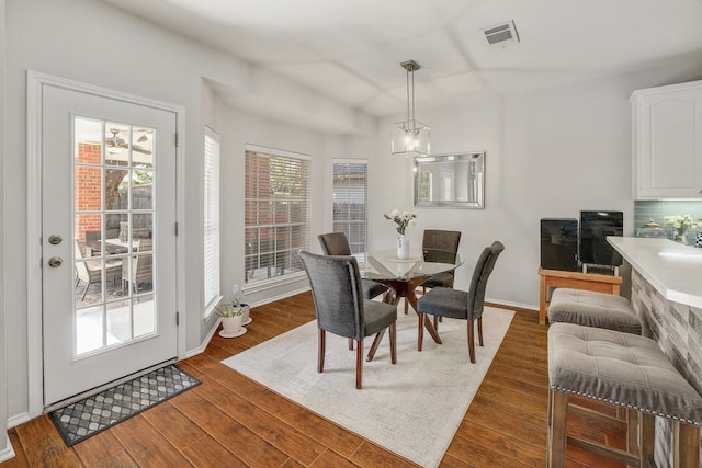 dining room with dark hardwood / wood-style flooring and a chandelier