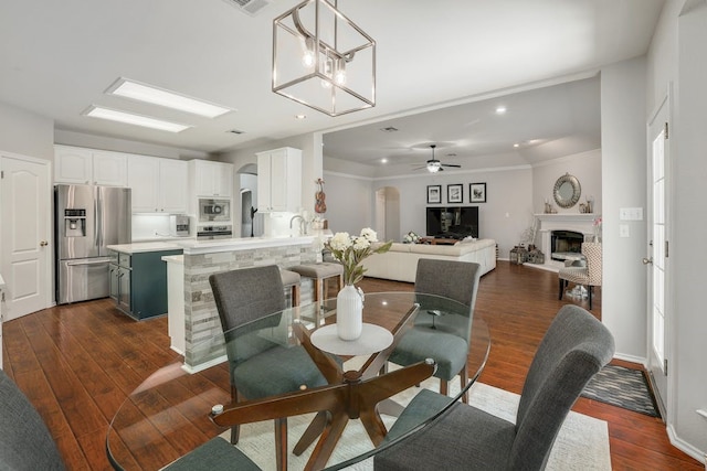 dining area with dark hardwood / wood-style floors, ceiling fan, and ornamental molding