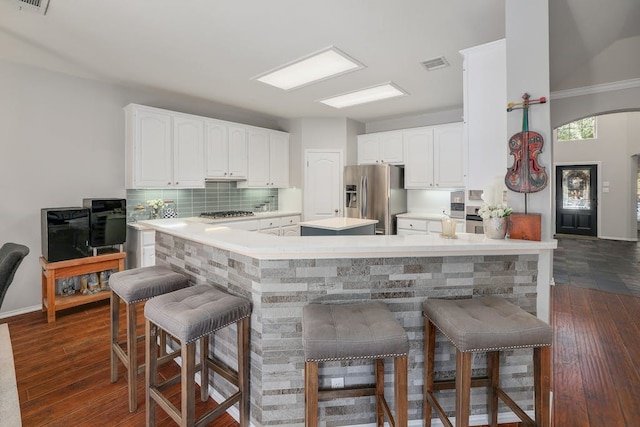 kitchen with a breakfast bar area, kitchen peninsula, and appliances with stainless steel finishes