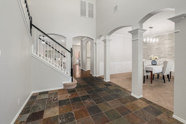 foyer entrance with dark colored carpet and a towering ceiling