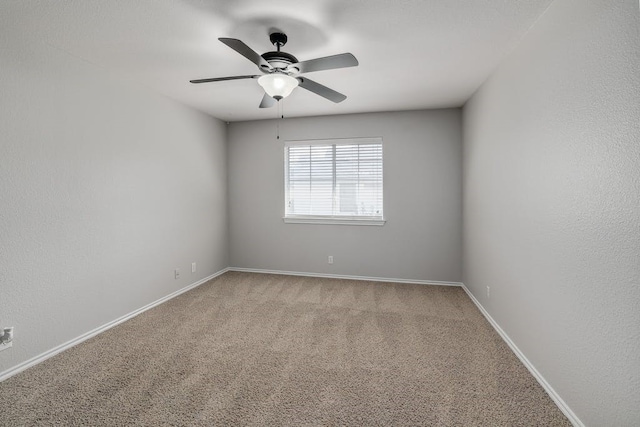 unfurnished room featuring ceiling fan and carpet