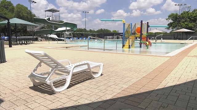 view of jungle gym with a patio area and a community pool