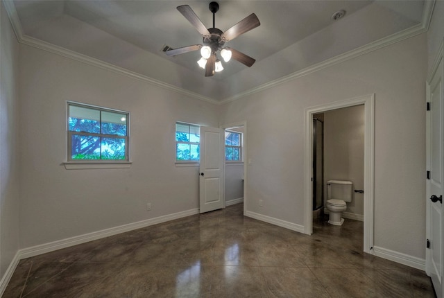 unfurnished bedroom featuring ornamental molding, a tray ceiling, ensuite bathroom, and ceiling fan