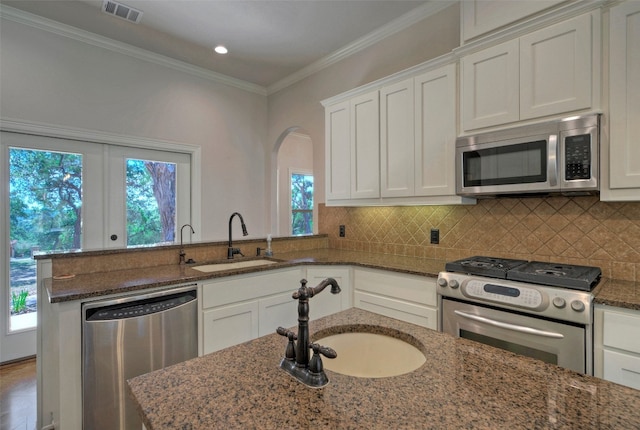 kitchen with stainless steel appliances, white cabinets, and a wealth of natural light