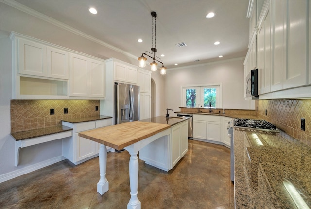 kitchen with pendant lighting, wood counters, decorative backsplash, white cabinets, and appliances with stainless steel finishes