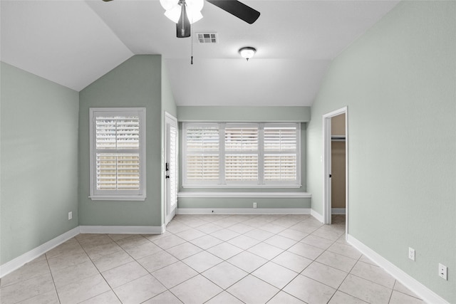 spare room featuring light tile patterned flooring, vaulted ceiling, and ceiling fan