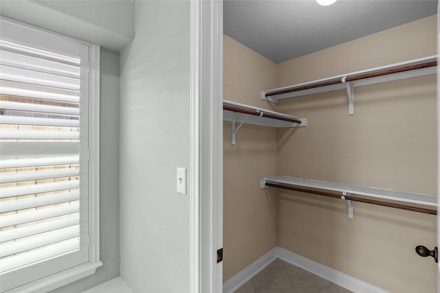 walk in closet with light tile patterned floors