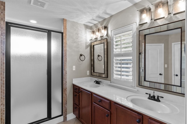 bathroom featuring an enclosed shower, vanity, and a textured ceiling