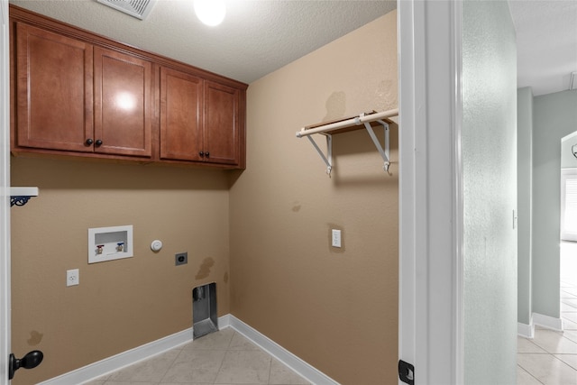 washroom featuring hookup for a gas dryer, hookup for a washing machine, electric dryer hookup, cabinets, and a textured ceiling