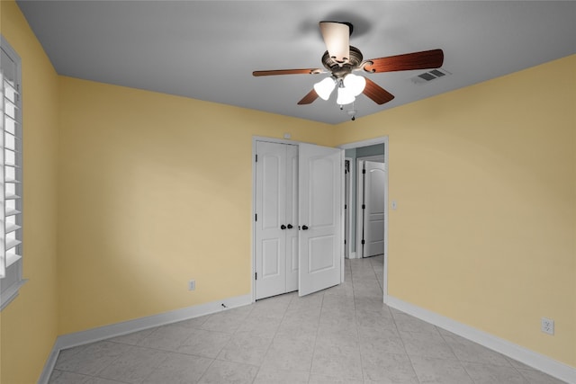 unfurnished bedroom with ceiling fan and a closet