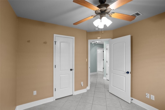 unfurnished bedroom with light tile patterned floors and ceiling fan