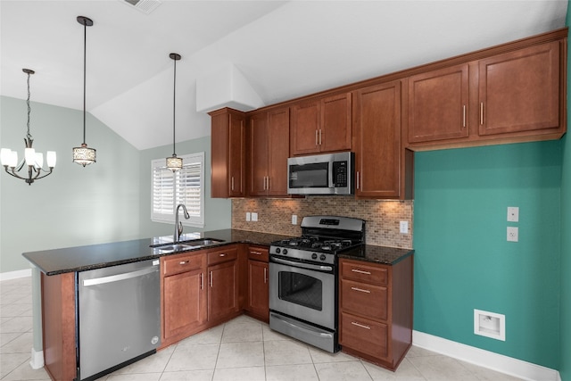 kitchen featuring lofted ceiling, stainless steel appliances, sink, an inviting chandelier, and decorative light fixtures