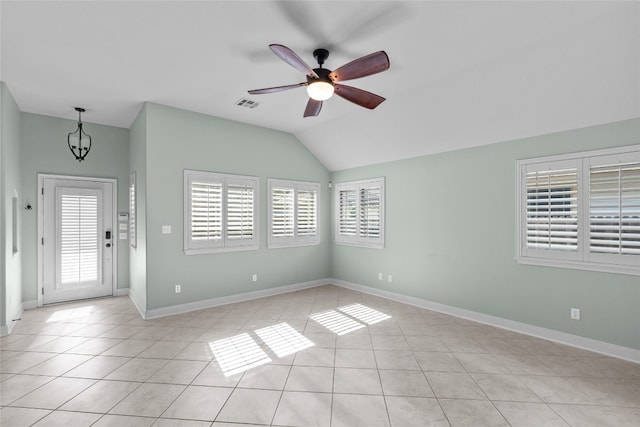 foyer with light tile patterned flooring, ceiling fan with notable chandelier, and lofted ceiling