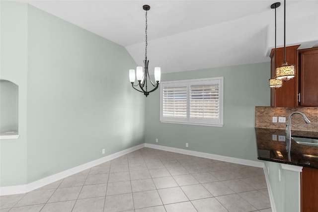 unfurnished dining area featuring a chandelier, vaulted ceiling, sink, and light tile patterned floors