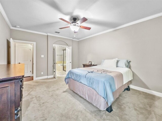 carpeted bedroom featuring crown molding, ceiling fan, and ensuite bath