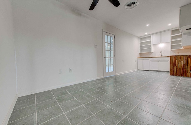 unfurnished living room featuring sink, light tile patterned floors, and ceiling fan