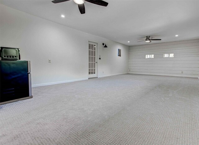 unfurnished living room with light colored carpet and ceiling fan