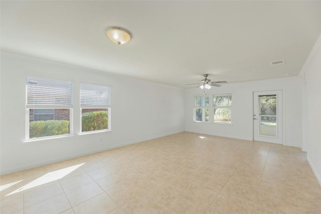 tiled empty room featuring ceiling fan and ornamental molding