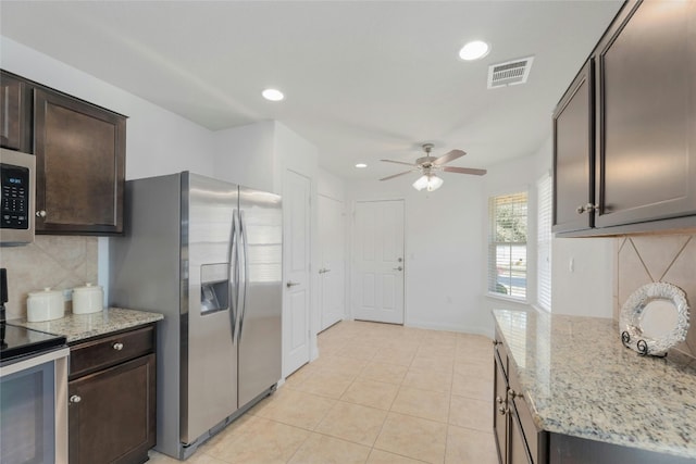 kitchen with dark brown cabinets, ceiling fan, light stone countertops, and appliances with stainless steel finishes