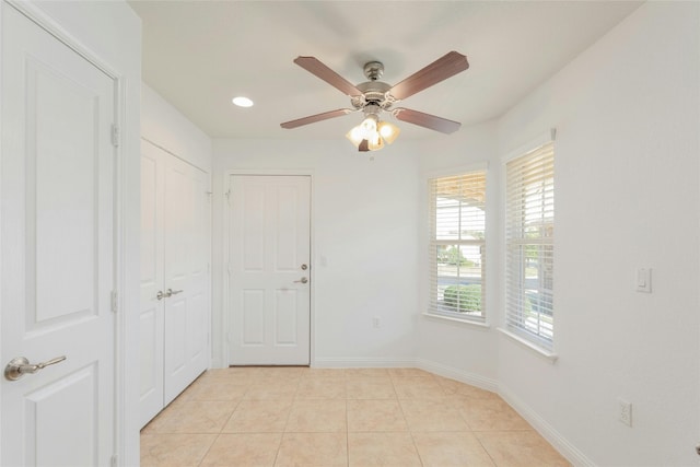 empty room featuring ceiling fan and light tile patterned floors