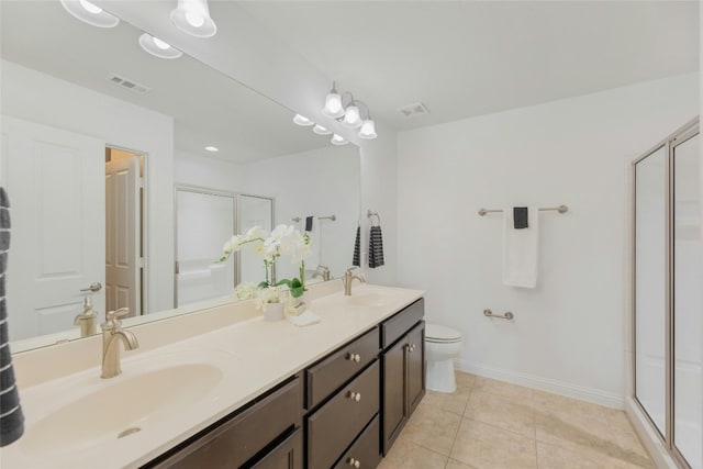 bathroom with tile patterned flooring, vanity, toilet, and a shower with door