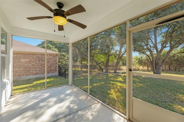 unfurnished sunroom featuring ceiling fan