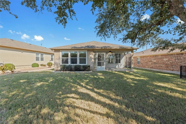 rear view of house with a yard and a sunroom