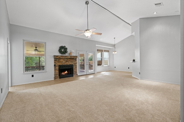 unfurnished living room with a fireplace, french doors, light carpet, and ceiling fan