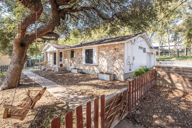 12614 Crystal Creek Dr, Buda, TX 78610 - view of front of home with stone siding, fence, and a garage