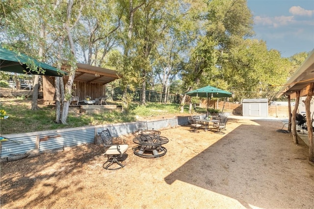 12614 Crystal Creek Dr, Buda, TX 78610 - fenced backyard featuring a fire pit, a shed, an outbuilding, and a patio area