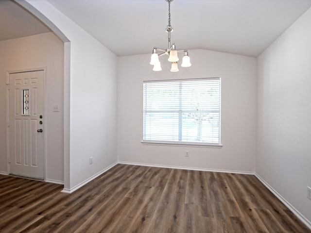 spare room featuring lofted ceiling, dark hardwood / wood-style floors, and a chandelier