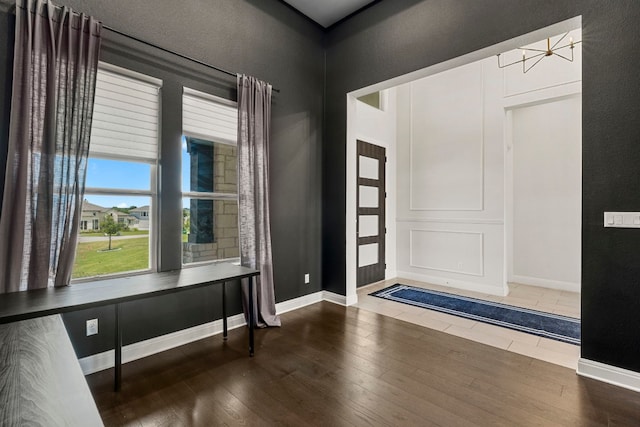 entryway with dark wood-type flooring and an inviting chandelier