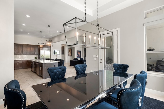 dining area featuring light tile patterned flooring, sink, and an inviting chandelier