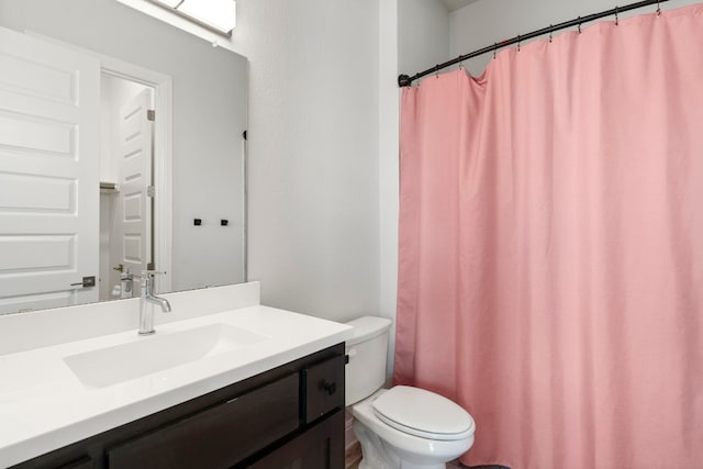 bathroom featuring toilet, vanity, and a shower with shower curtain