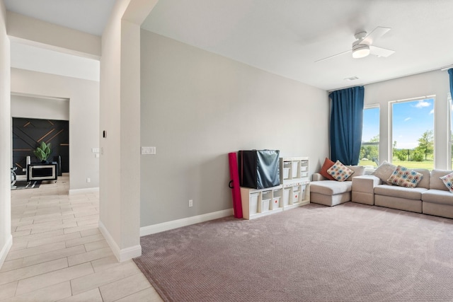 carpeted living room with ceiling fan