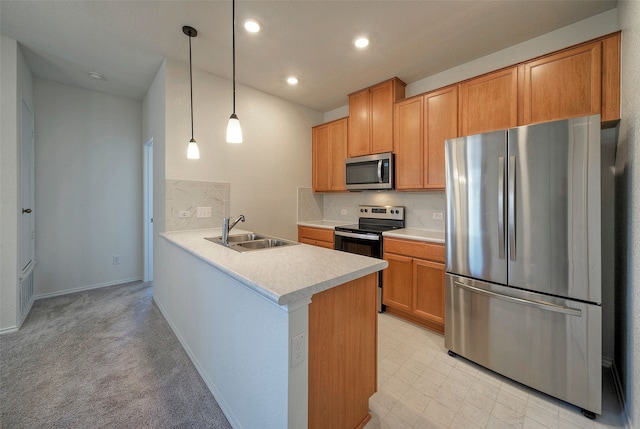 kitchen featuring appliances with stainless steel finishes, sink, hanging light fixtures, light colored carpet, and kitchen peninsula